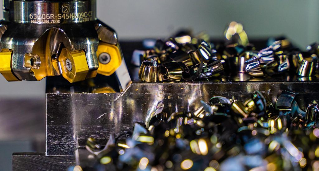 Eine Maschine schneidet in einem Metallbaubetrieb ein Metallteil