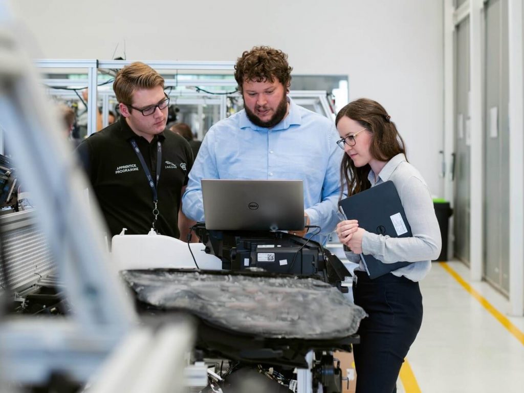 Gruppe von Personen, die gemeinsam Arbeitsanweisungen durchsehen