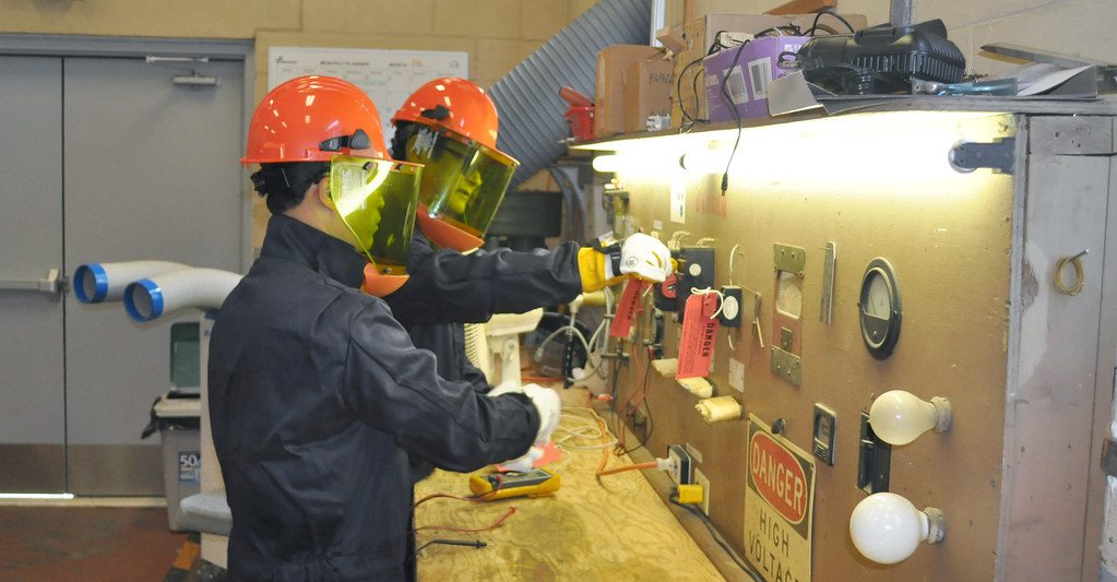 Two people carrying out a lockout/tagout procedure on equipment