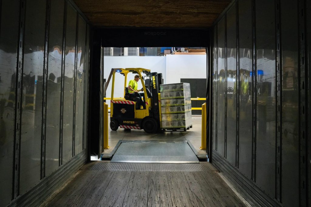 Worker using a forklift in a warehouse