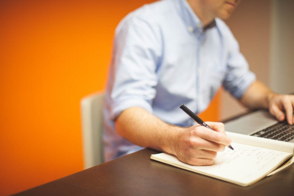 A man behind desk making notes to write work instructions