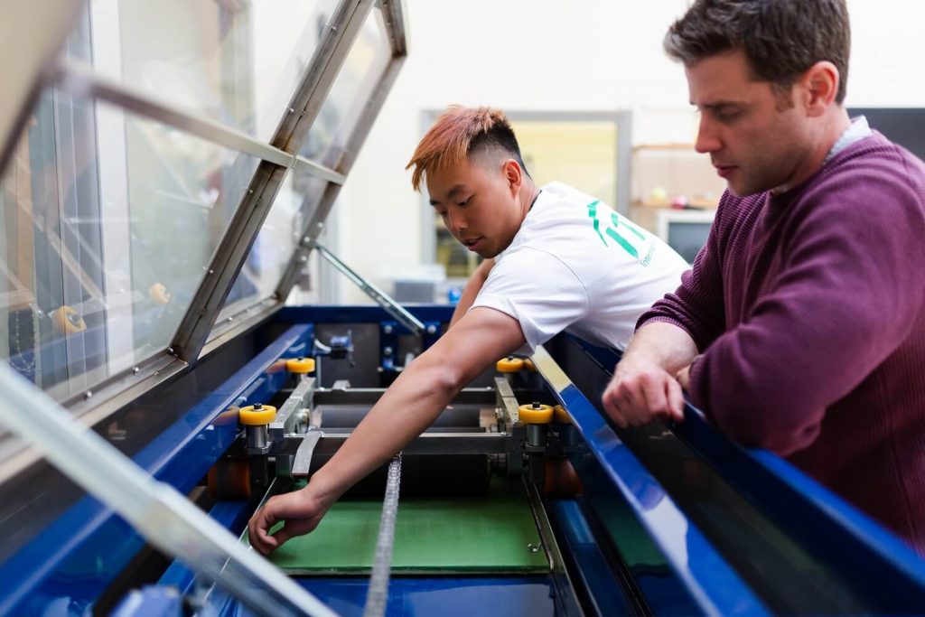 Worker going through on-the-job training with a water jet cutter