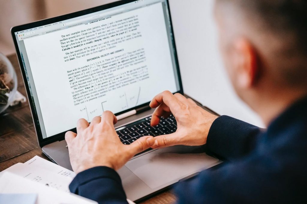 A man writing standard operating procedure on laptop